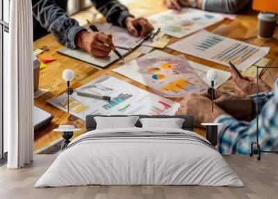 A group of people are sitting around a table with papers and a cell phone Wall mural