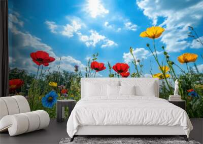 A meadow filled with wildflowers under a bright blue sky, conveying a sense of peace and natural beauty. Wall mural