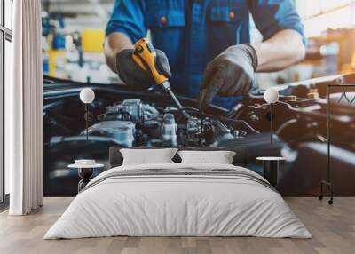 A mechanic working on a car engine in a well-equipped auto repair shop. Wall mural