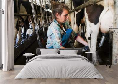 Young farmer woman Cow milking with facility and modern mechanized milking equipment Wall mural