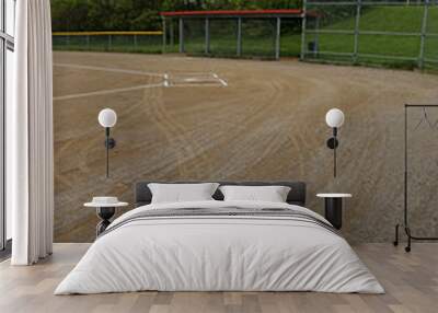 The on deck circle of an unoccupied baseball field on a cloudy day. Wall mural