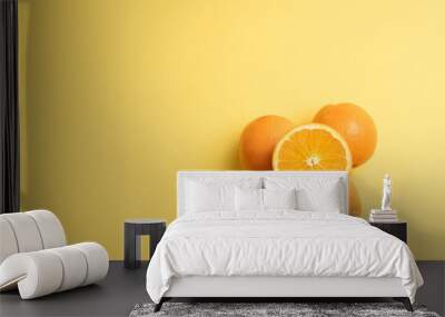 Vitaminas de Fruta naranjas cortadas sobre fondo amarillo liso para texto Wall mural