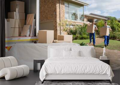 Movers carrying cardboard boxes from house to moving van Wall mural