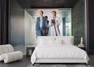 Scientist and businesswoman walking in hallway Wall mural