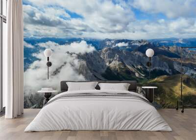 Sharp and rocky mountains range at Austrian-Italian border. There s a path mark on a stone. Serenity and peace. Clouds breaching high mountains. Lots of loose rocks, possibility of landslide Wall mural