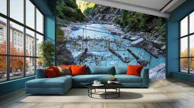 Well-worn suspension bridge, Annapurna Circuit Trek, Nepal. Not possible to cross that bridge, stones lying on it, net is broken. River flows in the gorge below the bridge. Clear day. Thriller, danger Wall mural