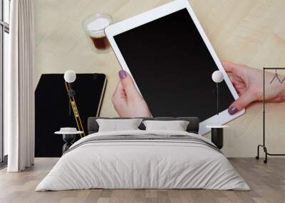 Girl hands holding a tablet pc with blank screen, wooden desk Wall mural