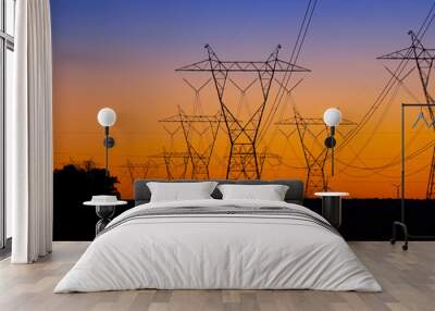 Silhouette High voltage electric towers at sunset time. High-voltage power lines. Electricity distribution station Wall mural