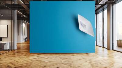 top view of white paper boat on blue background Wall mural