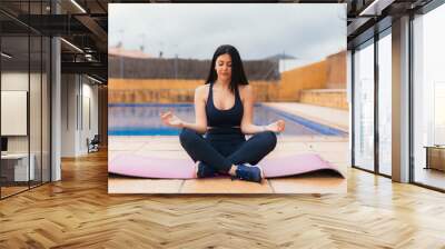 Brunette Caucasian female practicing yoga on a rrug Wall mural