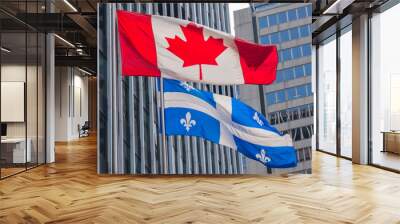 Quebec and Canada flags fluttering in the wind together in the downtown of Montreal. Wall mural