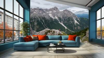 View into the valley Val Fiscalina in Sesto with an mountaineer women and the beautiful rock formations of the UNESCO World Heritage of the Dolomites mountains in the background. Wall mural