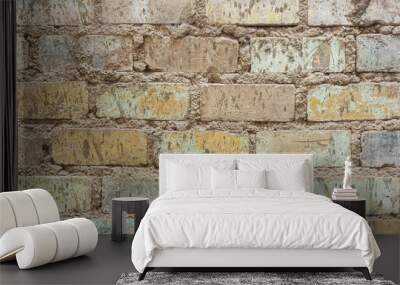 Distressed brick wall showcasing varied faded colors. Wall mural