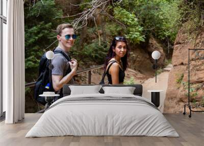 Adventurous couple looking at camera while exploring Utah wilderness together Wall mural