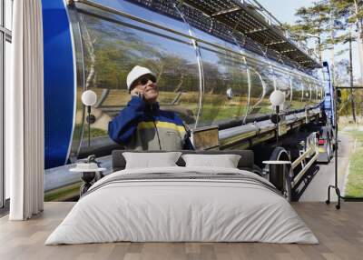 fuel truck and worker standing inside oil refinery, refuelling Wall mural