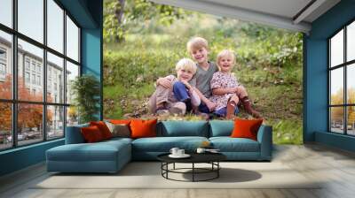 Family of Three Happy Young Children Posing Outside in Forest Wall mural