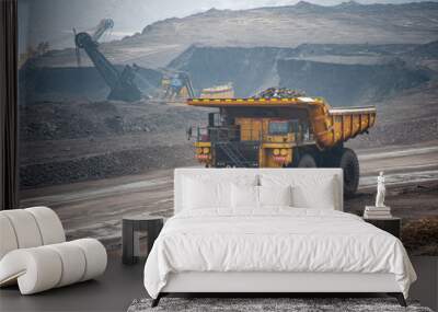 Big yellow mining truck hauling rock in dusty coal mine Wall mural