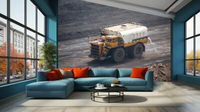 Big yellow truck spraying water in dusty Chinese coal mine Wall mural