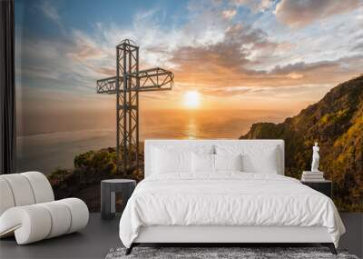 Monument crucifix on top of le morne mountain with a dramatic sunset background with yellow and orange colors Wall mural