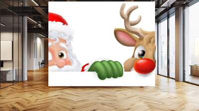 Cartoon Santa Claus or Father Christmas and his reindeer peeking over a sign Wall mural