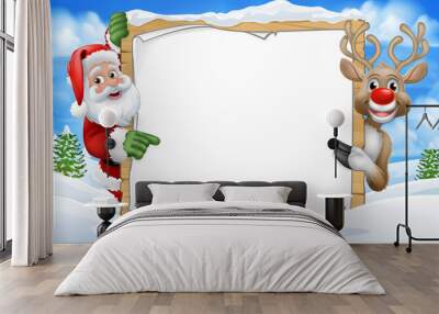 Santa Claus and Christmas reindeer peeking around a sign in a snowy scene winter landscape cartoon Wall mural