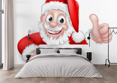 Santa Claus Christmas cartoon character peeking over a sign giving a thumbs up and pointing. Wall mural