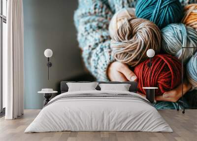 woman holding several balls of yarn in her hands, knitting and crocheting a sweater or cardigan with colorful threads and wool fabric. With copy space. Wall mural