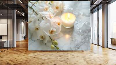 A candle is lit next to a bouquet of white flowers Wall mural