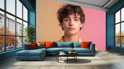 portrait of a teenage male in casual attire against a soft pastel backdrop. Wall mural