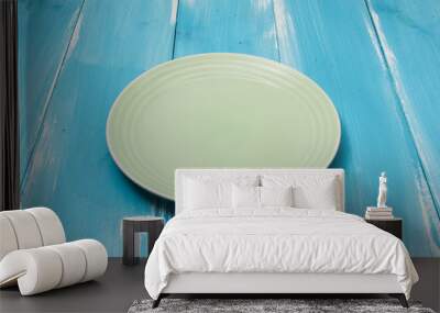 Green Round plate on blue wooden table with perspective Wall mural