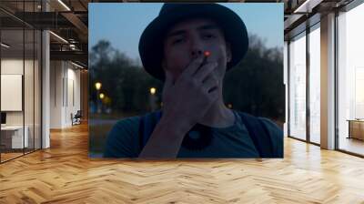 Portrait of a young man smoking a cigarette Wall mural