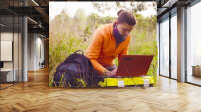 Woman scientist ecologist working on a laptop in the forest Wall mural