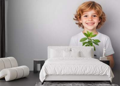 a happy child with a big smile holds a potted tree with both hands. isolated on white background  Wall mural