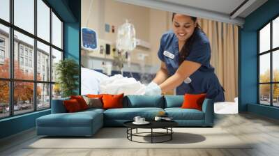 A female hospital cleaner cleans the patient's bed. Wall mural