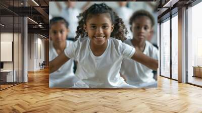 A group of cute, energetic little kids in white shirts and sports pants are stretching their muscles to warm up their bodies. play sports in school Wall mural