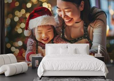 Asian mother and child wearing Christmas clothes, cooking and decorating cookies Wall mural