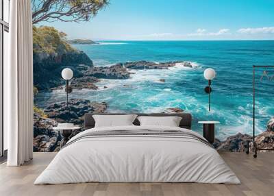 Beautiful beach rocks with blue water and clear sky with waves on a sunny summer day. Wall mural