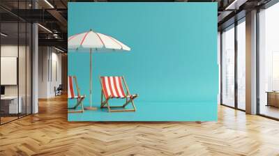 Two colorful beach chairs and a parasol for relaxing on isolated blue background with copy space. Wall mural