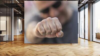 Man making clenched fist at camera. Selective focus Wall mural