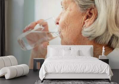 Healthy, hydration and senior woman drinking water for wellness and liquid diet detox at home. Thirsty, fresh and calm elderly female person enjoying glass of cold drink in modern retirement house. Wall mural