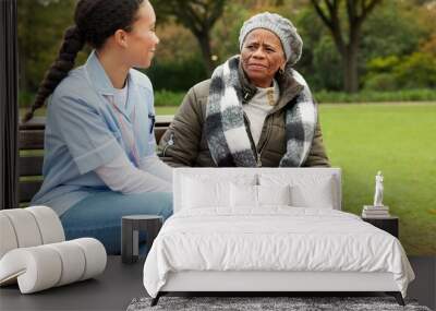 Nurse, happy and relax with old woman on park bench for retirement, elderly care and conversation. Trust, medical and healthcare with senior patient and caregiver in nature for nursing rehabilitation Wall mural