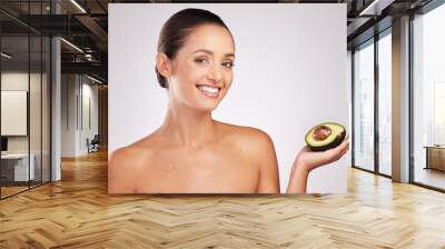 Skincare, woman and avocado in studio with portrait for anti aging, moisturize or glowing skin on white background. Wellness, fruit and hand of model for omega 3, dermatology or organic cosmetics Wall mural