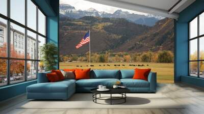 Waving American flag on the Weber Ranch with a cattle grazing grass near Ridgway, Colorado Wall mural