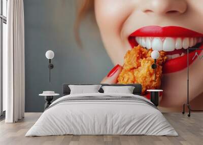 A close-up of a woman with bold red lips biting into crispy fried chicken, showcasing the indulgence and joy of savoring delicious comfort food. Wall mural