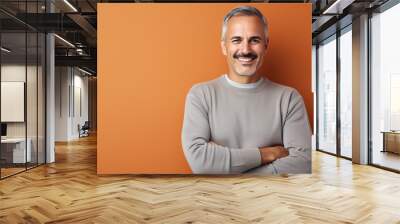 A mature man with a joyful expression in front of a colorful backdrop.. Wall mural