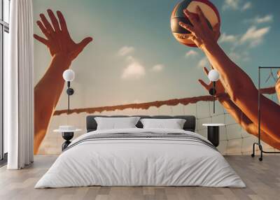 close-up of two athletes playing beach volleyball, their hands reaching high in the air to hit the ball Wall mural