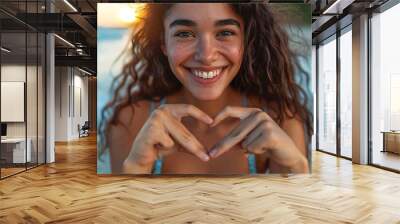 Close-up photo of happy lady in swimsuit at the beach forming a heart with her hands - Beautifully gleeful Latina woman posing for camera outdoors Wall mural