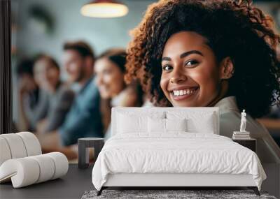 Close-up of a young black woman smiling in the office, in the background other people Wall mural