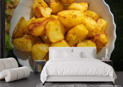 Potatoes fried in a frying pan close-up, lying on a white plate, Horizontal view from above, food background Wall mural