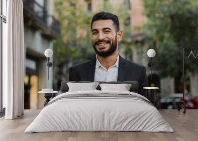 Handsome arabic guy smiling. Successful man walking on the street Wall mural